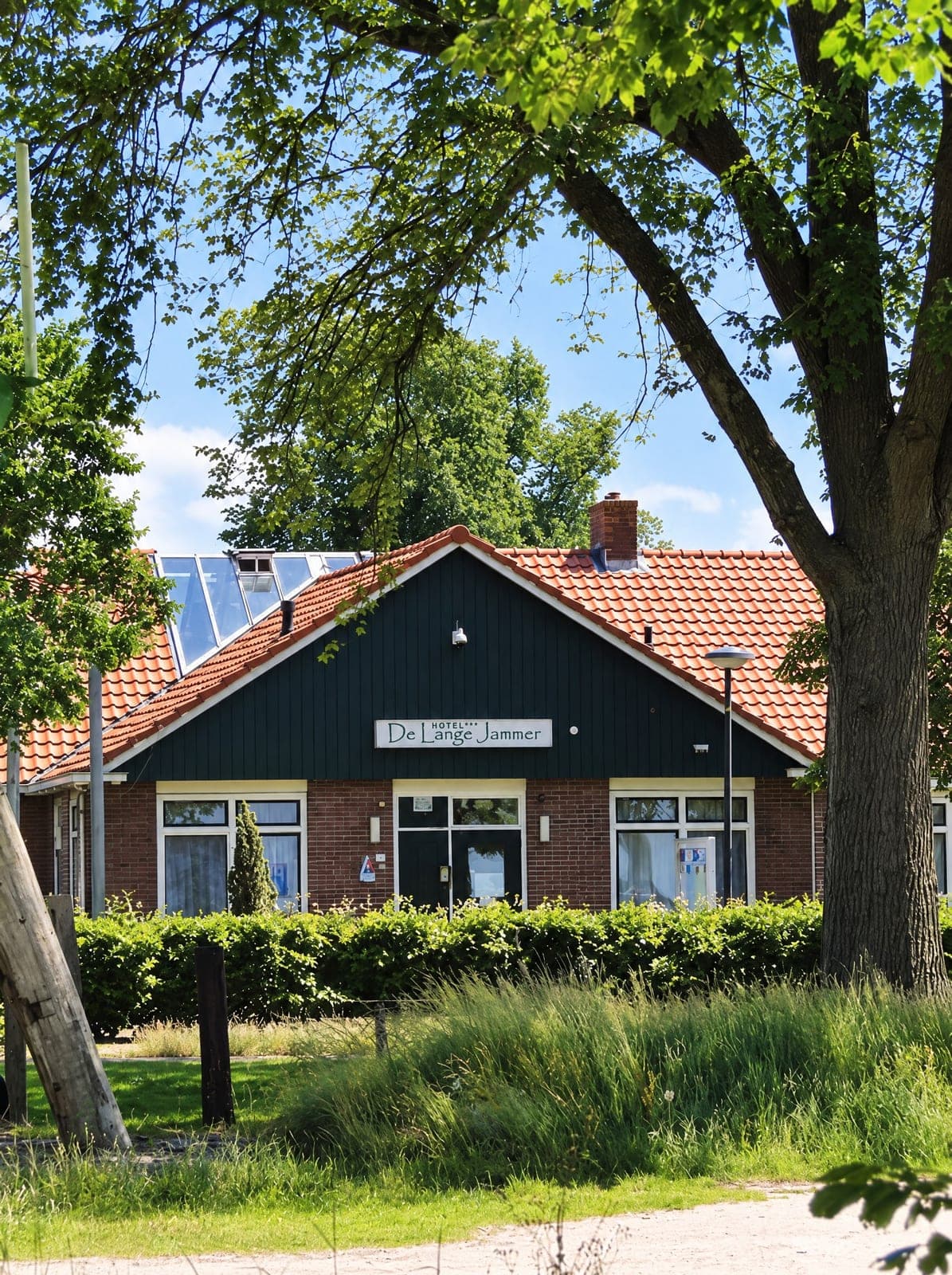 De voorgevel van Hotel de Lange Jammer, met het naambord tussen de bomen