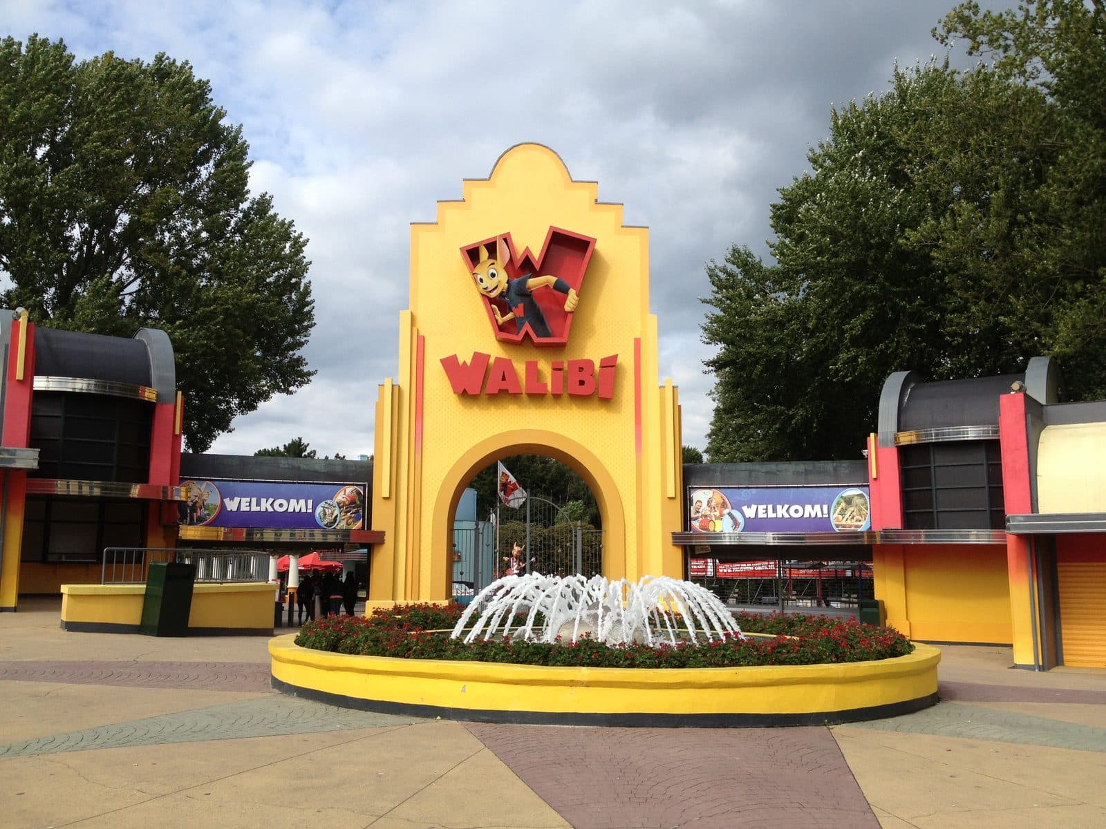 De gele toegangspoort van Walibi Holland met de fontein ervoor